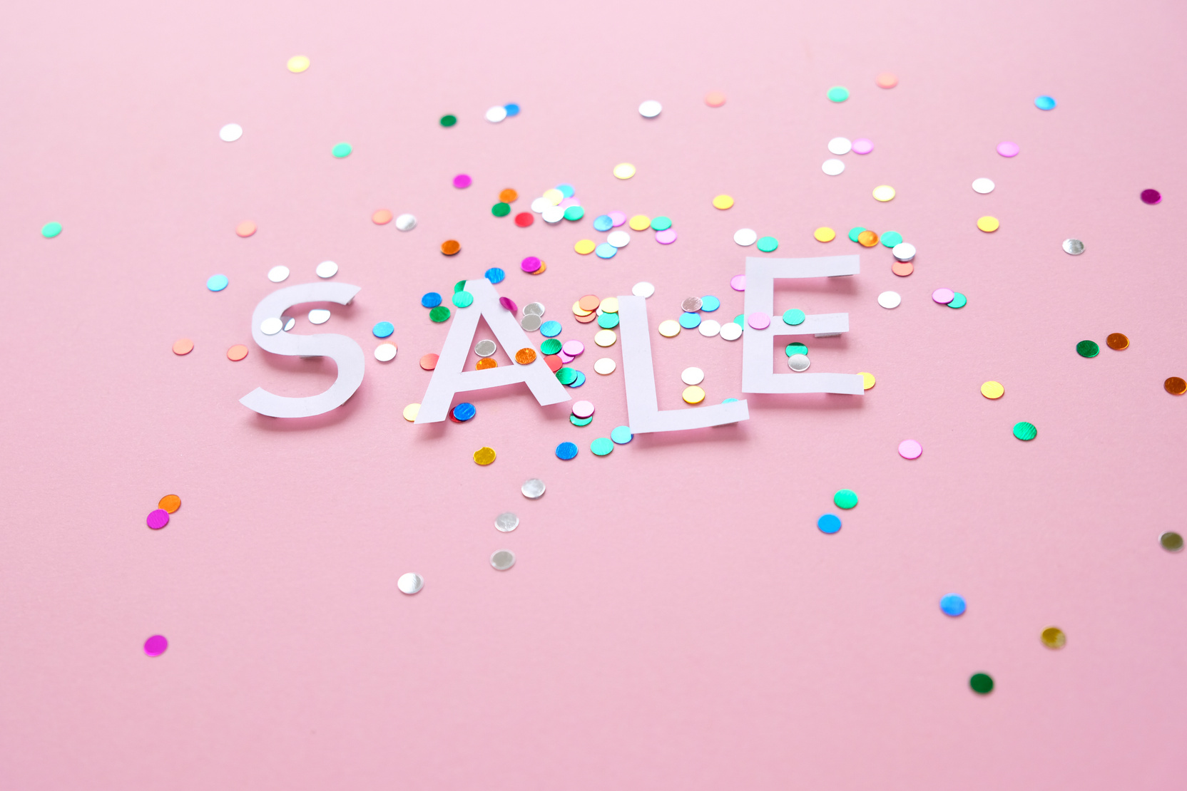 Sale with colorful confetti on pink background